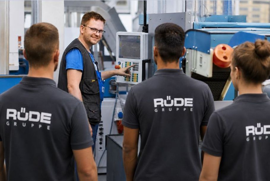 Stellvertretender Produktionsleiter instruiert seine Mitarbeitenden wie die Produktionsmaschine eingestellt werden soll.